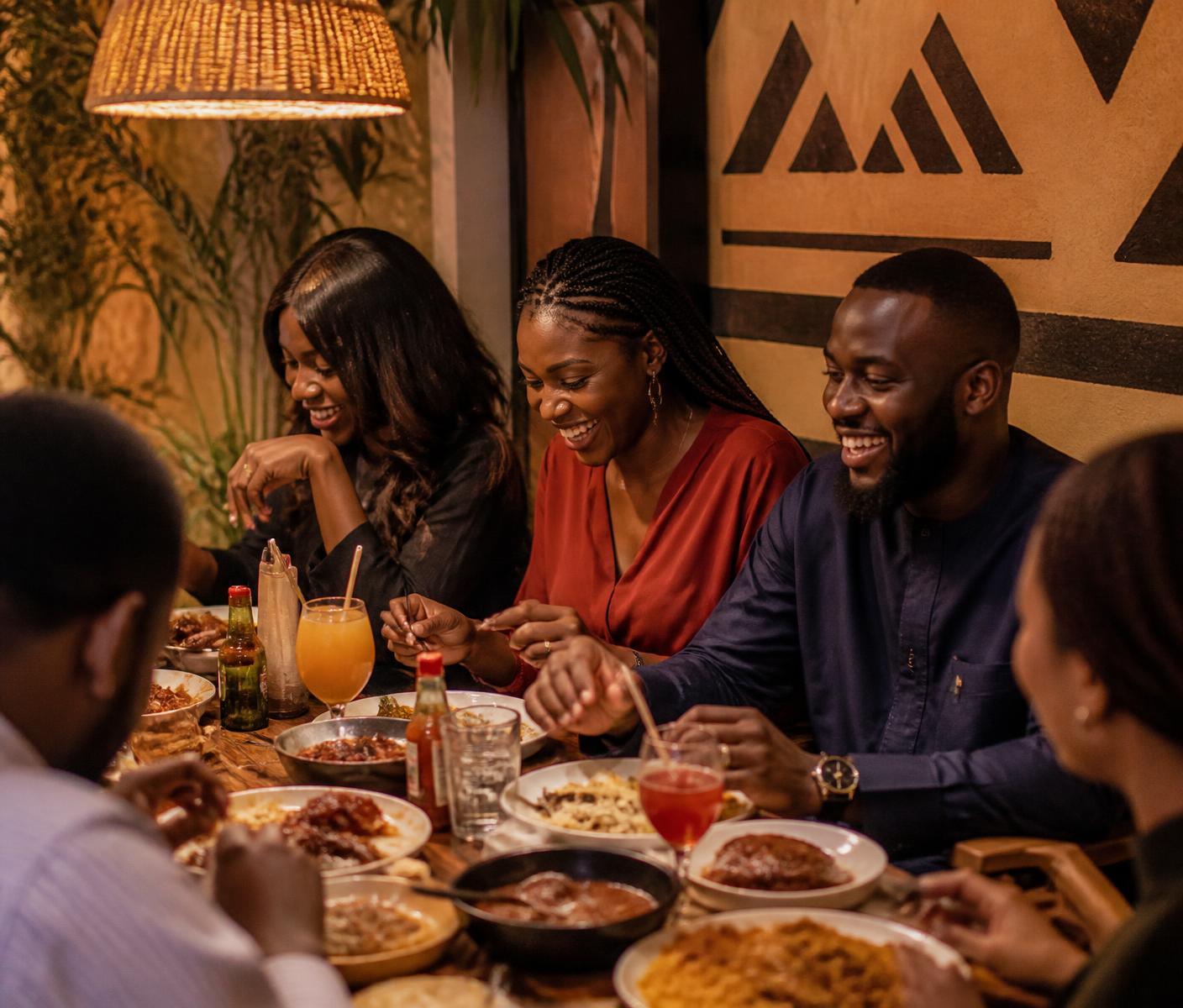 Friends sharing a meal and drinks together at Onowu's Kitchen & Bar